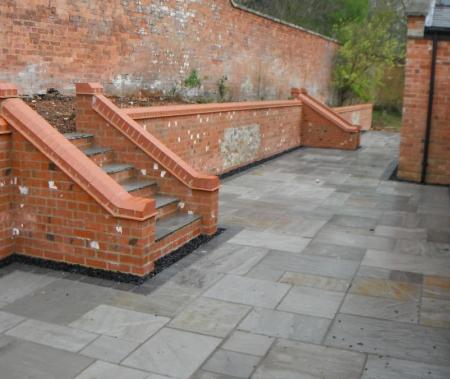 newly paved patio with steps providing easy access to raised beds