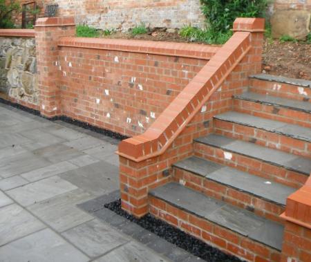 New brick staircase provides easy access to reconstructed raised bed and retaining wall